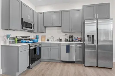 a kitchen with gray cabinets and stainless steel appliances at Stunning 2BR-1B Apt+Mins to Zoo& D/T+HD Projector in Cleveland