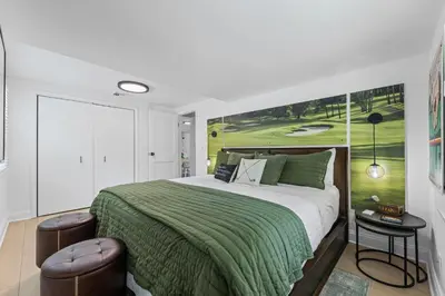a bedroom with a large bed with a green blanket at Blissful Serenity - Walk to Lake Milton with Hot Tub in Lake Milton