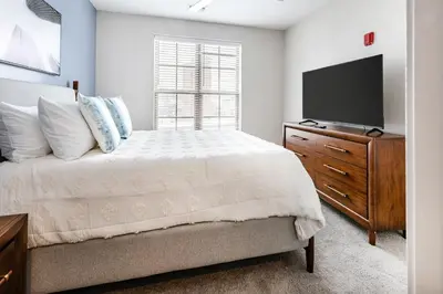 a bedroom with a bed and a dresser with a television at Landing Stylish 1BD Gym Courtyard in Cleveland