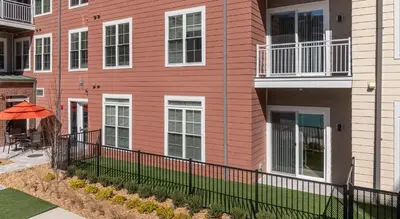 a pink building with a fence in front of it at Landing Stylish 1BD Gym Courtyard in Cleveland