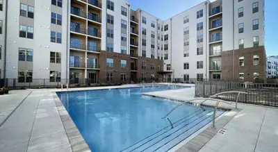 a large swimming pool in an apartment complex with buildings at Landing Stylish 1BD Gym Courtyard in Cleveland