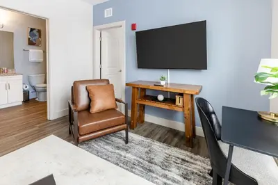 a living room with a desk with a tv and a chair at Landing Stylish 1BD Gym Courtyard in Cleveland
