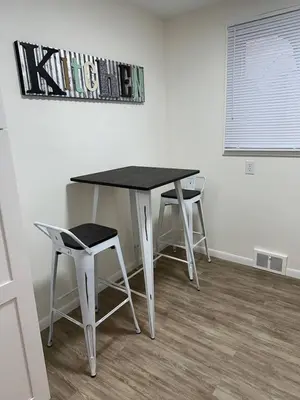 a table and two stools in a room at Charming Mentor Home w/ Fenced Backyard in Mentor