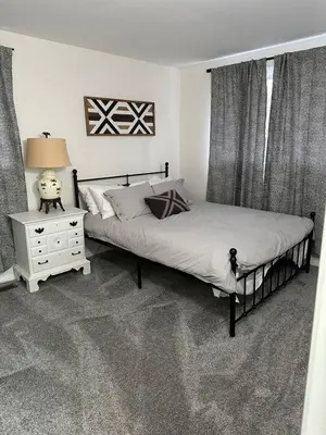 a bedroom with two beds and a lamp and a night stand at Charming Mentor Home w/ Fenced Backyard in Mentor