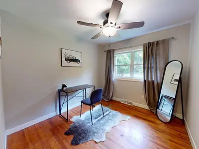 a room with a desk and a mirror and a ceiling fan at Rustic Kirtland Farmhouse Retreat in Kirtland