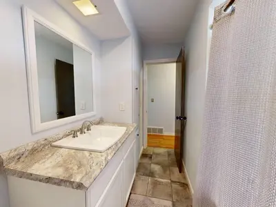 a white bathroom with a sink and a shower at Rustic Kirtland Farmhouse Retreat in Kirtland