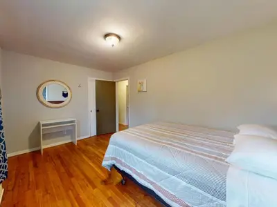 a bedroom with a large bed and a mirror at Rustic Kirtland Farmhouse Retreat in Kirtland