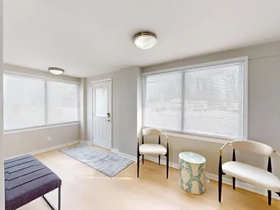 a living room with two chairs and two windows at Stylish Home Near Historic Downtown & Lake Erie in Willoughby