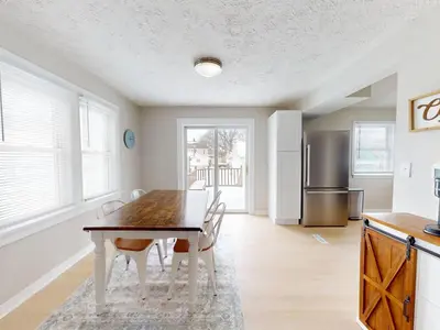 a kitchen with a table and chairs and a refrigerator at Stylish Home Near Historic Downtown & Lake Erie in Willoughby