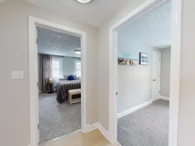 a white room with a bed and a doorway at Stylish Home Near Historic Downtown & Lake Erie in Willoughby