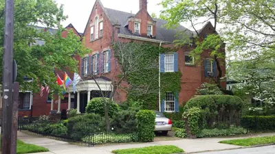 a red brick house with a car parked in front of it at Clifford House Private Home B&B in Cleveland