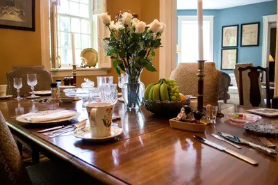 a dining room table with a vase of flowers on it at Clifford House Private Home B&B in Cleveland