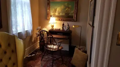 a room with a chair and a lamp and a table at Clifford House Private Home B&B in Cleveland