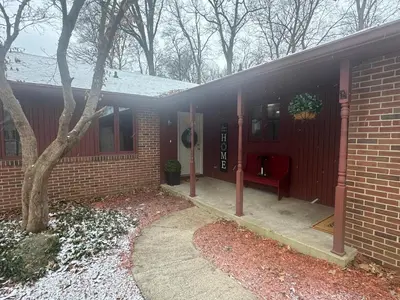 a red brick house with a red bench on the porch at Muncie 3 bedroom 2 bath brick home in Muncie