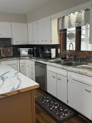 a kitchen with white cabinets and a sink at Muncie 3 bedroom 2 bath brick home in Muncie