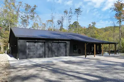 a black building with two garage doors at Pine Grove Barndominium in Sugar Grove