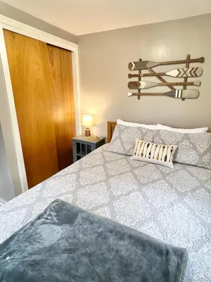 a bedroom with a bed with a gray and white bedspread at Salt Creek Cabin in Chillicothe