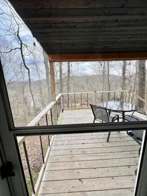 a porch with a table and a bench on a deck at Salt Creek Cabin in Chillicothe