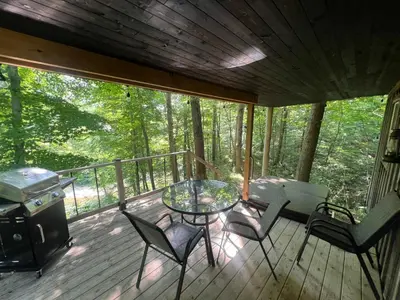 a screened in porch with a table and chairs at Salt Creek Cabin in Chillicothe