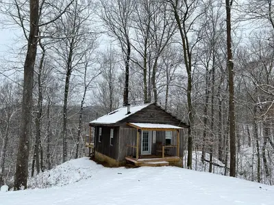 a small cabin in the woods in the snow at Salt Creek Cabin in Chillicothe