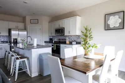 a kitchen with a wooden table and white cabinets at Holistic Campus Rental, LLC in Oxford