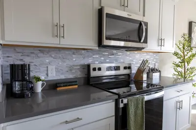 a kitchen with white cabinets and a stove top oven at Holistic Campus Rental, LLC in Oxford