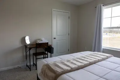 a bedroom with a bed and a desk and a window at Holistic Campus Rental, LLC in Oxford