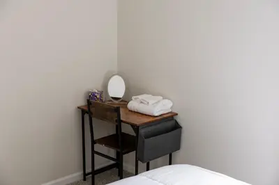 a dressing table with a mirror and a bed at Holistic Campus Rental, LLC in Oxford