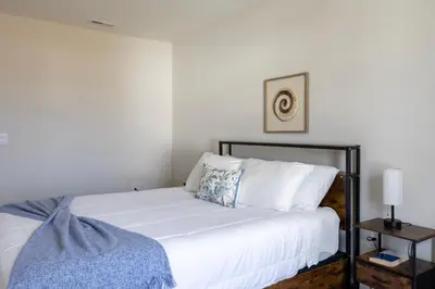 a bedroom with a bed with white sheets and pillows at Holistic Campus Rental, LLC in Oxford