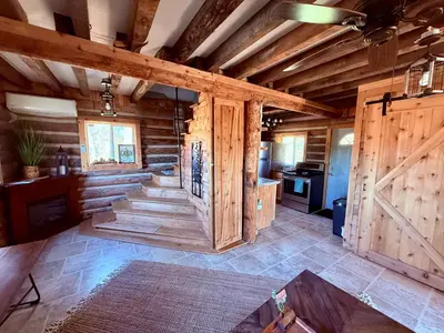 a large room with wooden walls and stairs in a house at Walnut Creek Cabin in Chillicothe