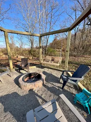 a patio with a fire pit and chairs and a bench at Walnut Creek Cabin in Chillicothe