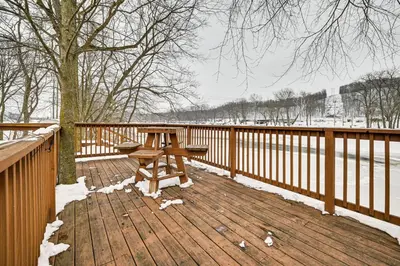 a picnic table on a wooden deck in the snow at Deck and Fire Pit! Muskingum Fishing Cabin in Dresden