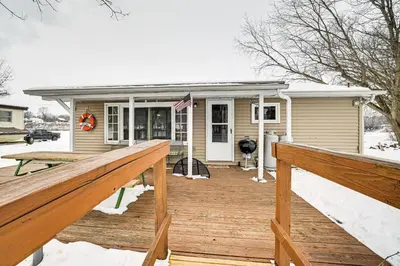 a house with a wooden deck in the snow at Deck and Fire Pit! Muskingum Fishing Cabin in Dresden