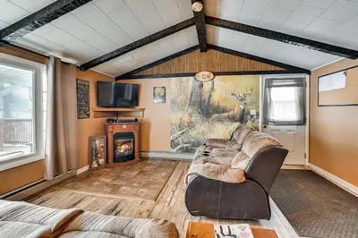 a living room with leather furniture and a fireplace at Deck and Fire Pit! Muskingum Fishing Cabin in Dresden