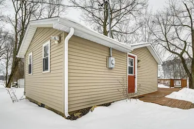 a small house in the snow with a door at Deck and Fire Pit! Muskingum Fishing Cabin in Dresden