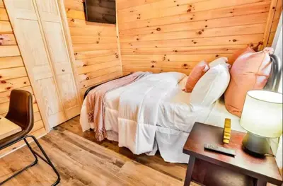 a bedroom with a bed and a table with a lamp at Timber Ridge Cabin in Louisa