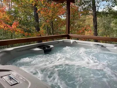 a jacuzzi tub sitting on top of a porch at Timber Ridge Cabin in Louisa