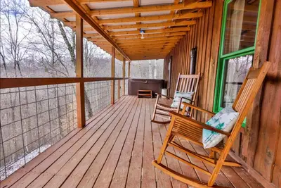 a porch of a cabin with two rocking chairs on it at Timber Ridge Cabin in Louisa