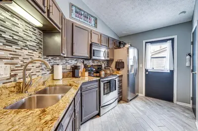 a kitchen with a sink and a refrigerator at Castlerea Casa! Columbus Area Home with Yard in Hilliard