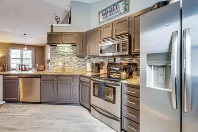 a kitchen with stainless steel appliances and brown cabinets at Castlerea Casa! Columbus Area Home with Yard in Hilliard