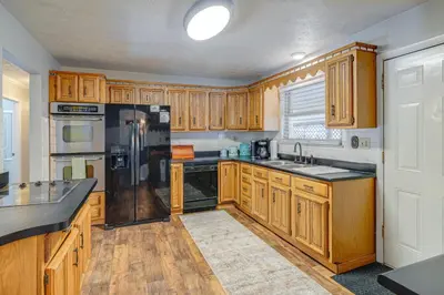 a kitchen with wooden cabinets and black appliances at half Mi to Kanawha River Quiet Escape with Patio in Chesapeake