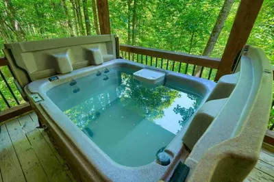 a jacuzzi tub on the deck of a cabin at Romantic Logan Cabin with Private Year Round Hot Tub Near Hocking Hills in Logan