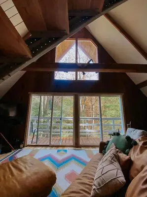 a room with a bed and a large window at Hillside Haven Treehouse Cabin in Rockbridge