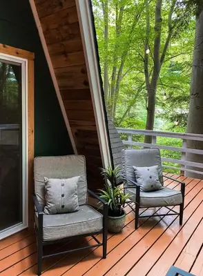 two chairs sitting on the porch of a house at Hillside Haven Treehouse Cabin in Rockbridge
