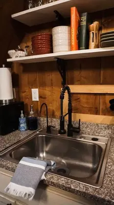 a kitchen sink with a towel next to it at Hillside Haven Treehouse Cabin in Rockbridge