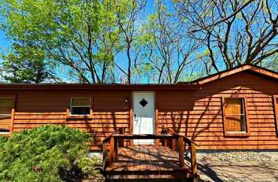 a small wooden house with a white door at Put-in-Bay Island Club #12 in Put-in-Bay