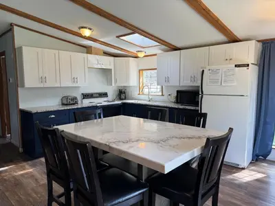 a kitchen with a table with chairs and a refrigerator at Put-in-Bay Island Club #63 in Put-in-Bay