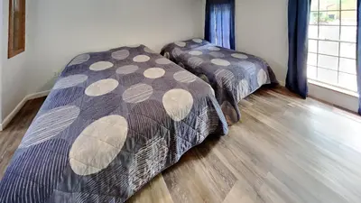 two beds in a room with wooden floors at Put-in-Bay Island Club #63 in Put-in-Bay