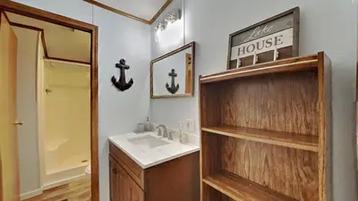 a bathroom with a sink and a house sign on the wall at Put-in-Bay Island Club #63 in Put-in-Bay