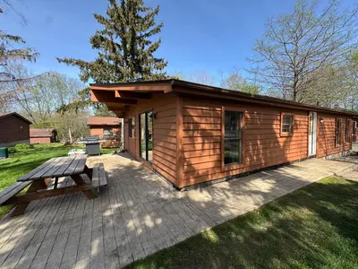 a wooden cabin with a picnic table on a deck at Put-in-Bay Island Club #63 in Put-in-Bay